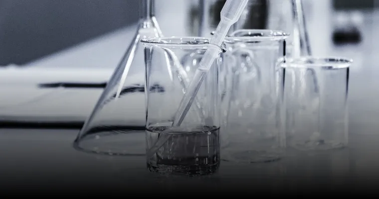 Laboratory glassware with a pipette on a lab bench.